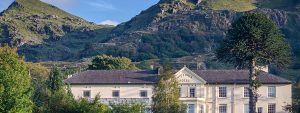 The Royal Victoria Hotel with gardens and mountains in Llanberis